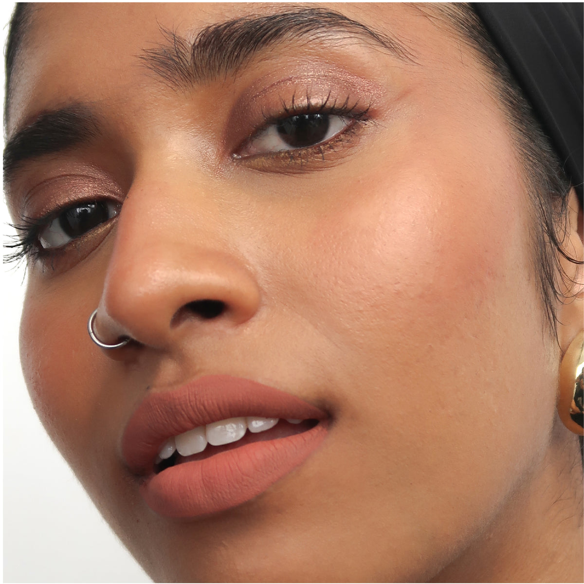 Peptide Hydra-Matte Lipstick in Cinnamon on tan skin