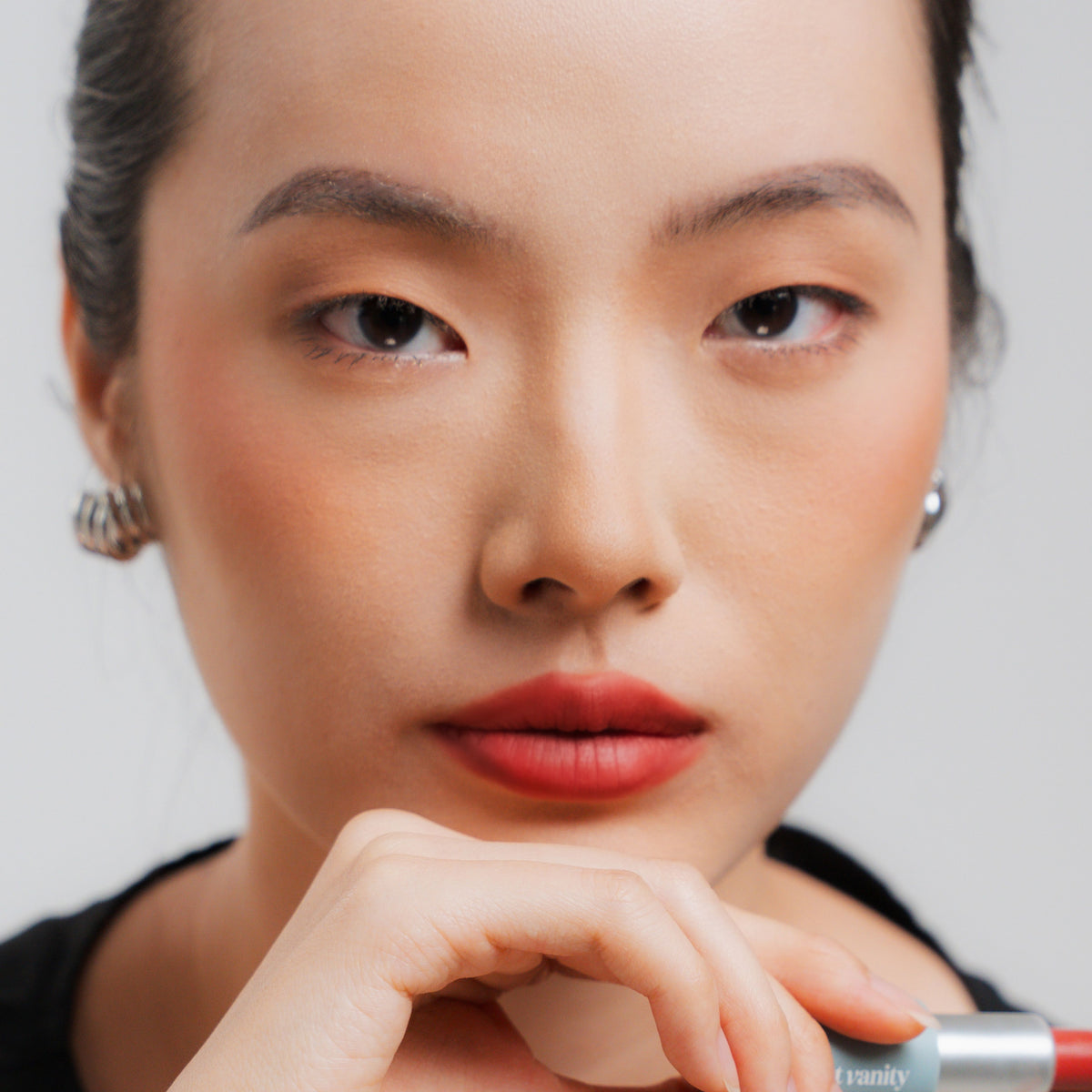 Soft Blur Glide-On Lipstick in Poppy on fair skin