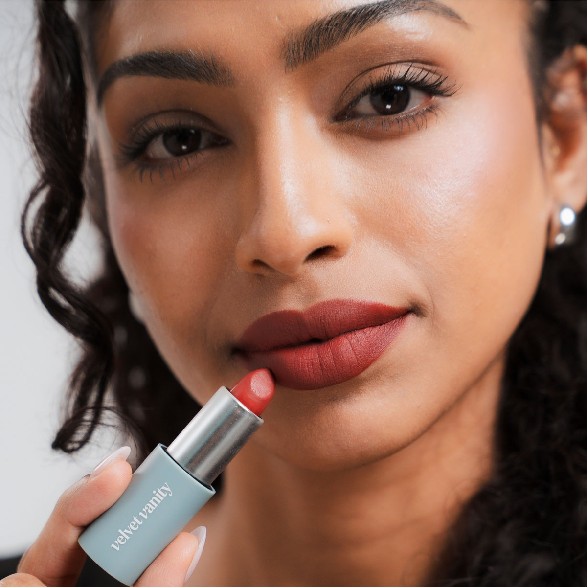 Soft Blur Glide-On Lipstick in Poppy on tan skin
